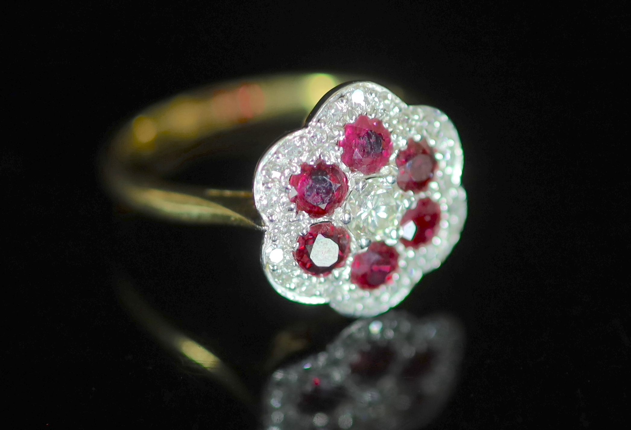 A modern 18ct gold, ruby and diamond set flower head cluster ring